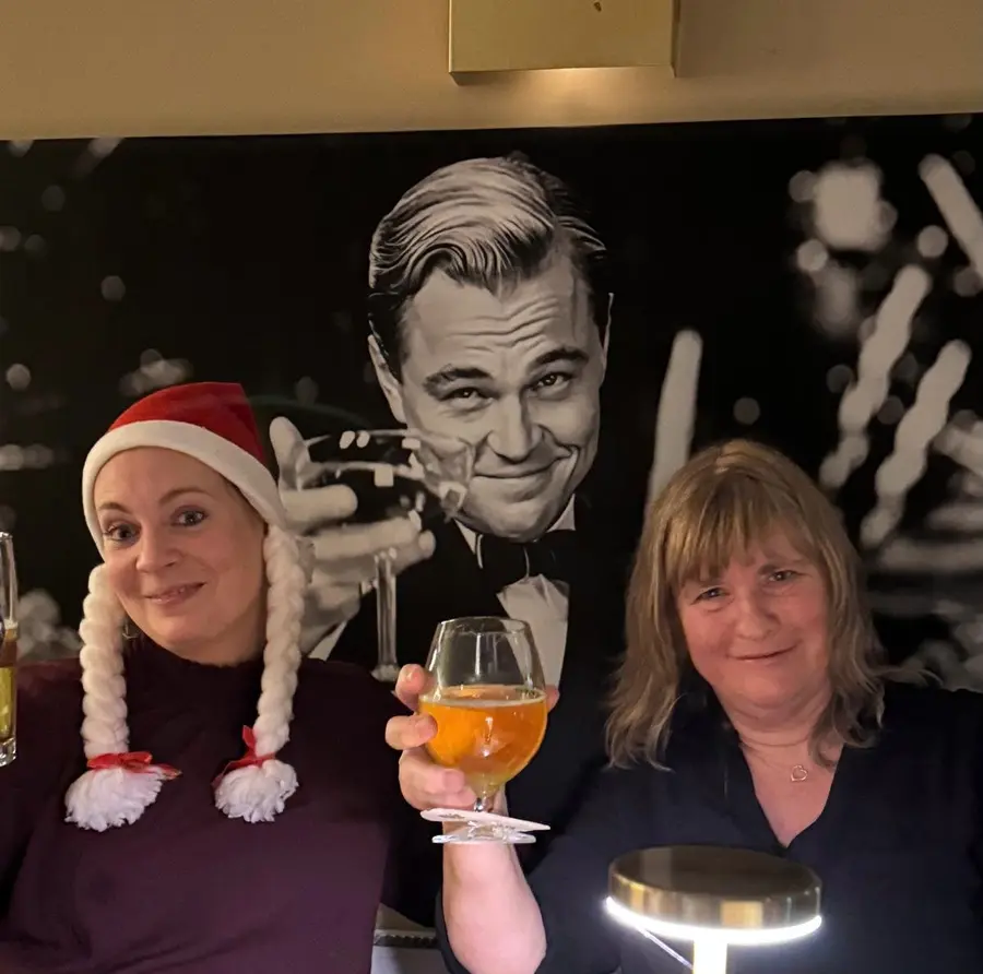Zwei Kolleginnen stoßen bei der Weihnachtsfeier an